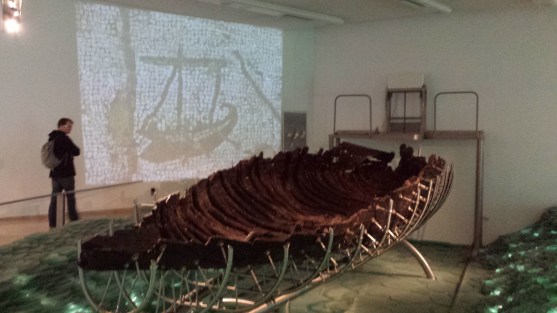 The Jesus boat - notice the image projected on the wall behind it from an old mosaic of exactly this type of boat