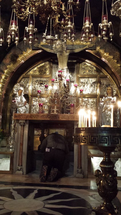 Bishop Greg at the shrine. Pilgrims can kneel under the altar and reach down through a hole to touch the bed rock.